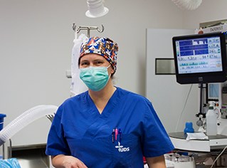 Djurskötare Kiki i operationskläder och med munskydd. Foto.